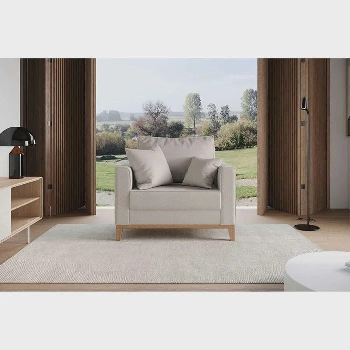 Poltrona bege em sala decorada com pés de madeira clara e almofadas